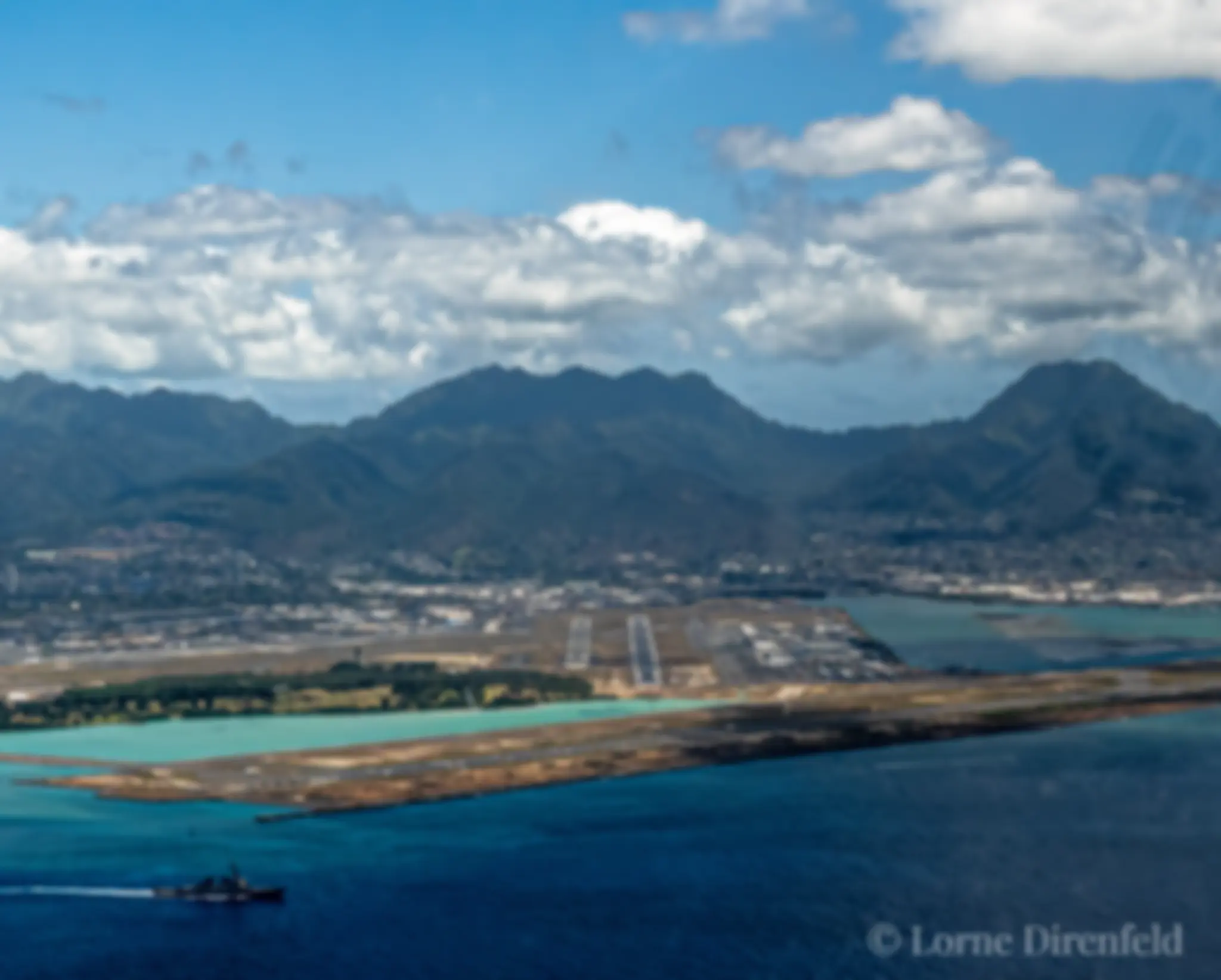 Coming in for landing, overflying the reef runway, as a ship leaves Pearl Harbor . . .