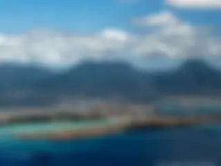Coming in for landing, overflying the reef runway, as a ship leaves Pearl Harbor . . .