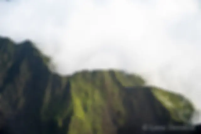 The lush green crests of west Maui mountains, filled with clouds . . .